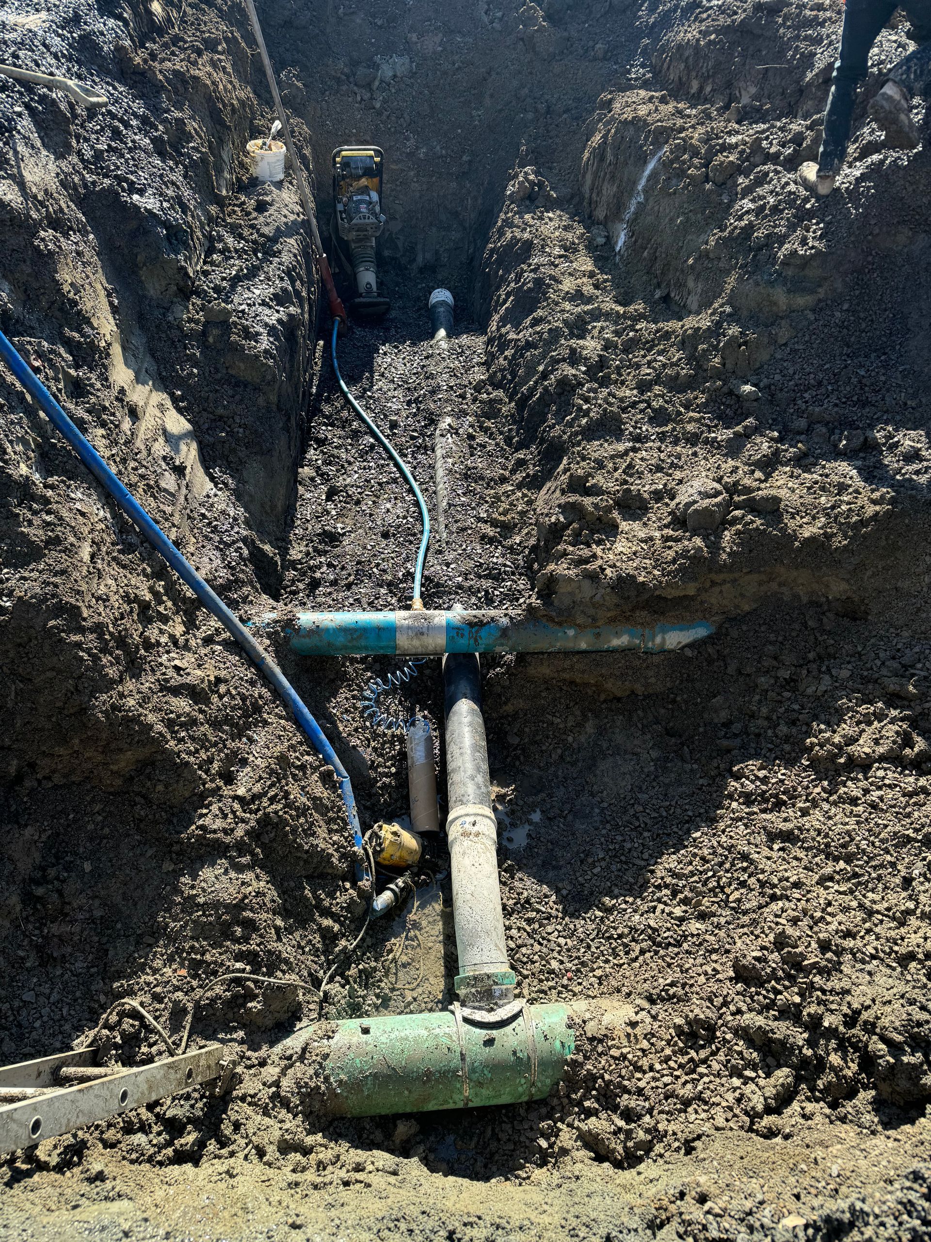 Un tuyau est posé dans la terre dans une tranchée.