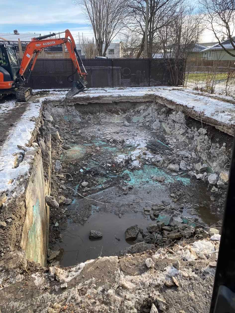 Une grande excavatrice creuse un trou dans le sol.