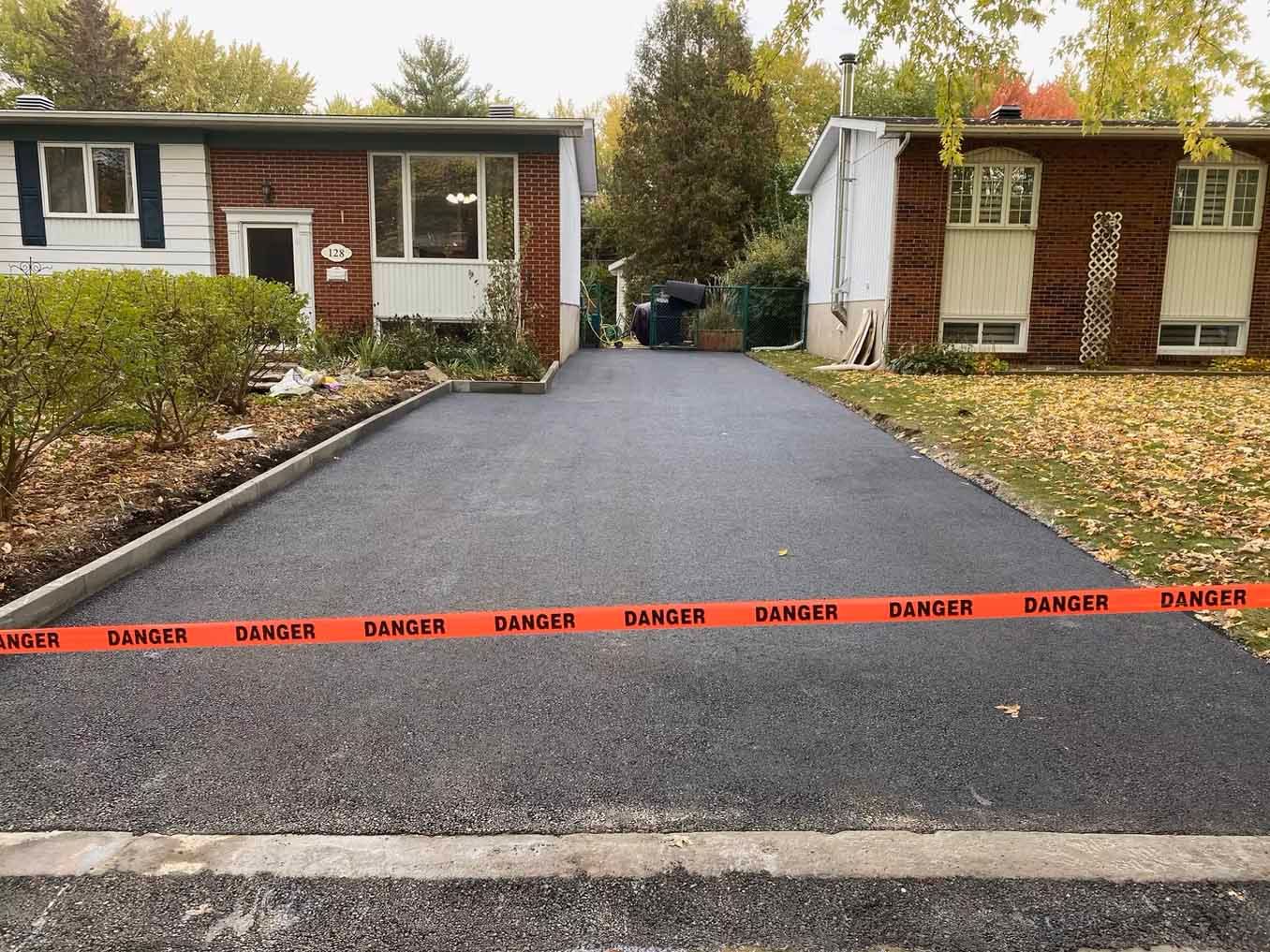 Une allée entre deux maisons avec un ruban de danger dessus