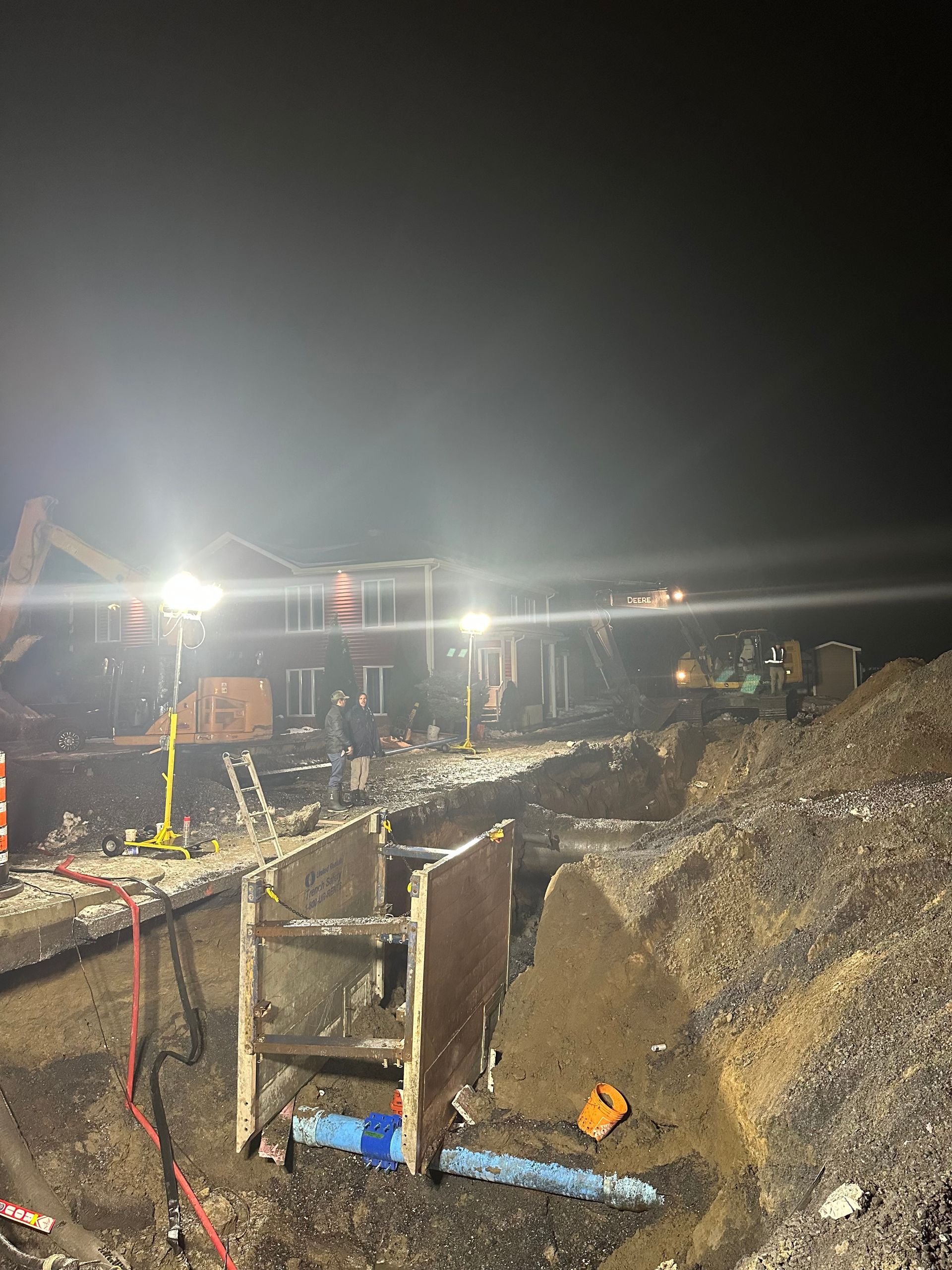 Un chantier de construction la nuit avec beaucoup de lumières allumées.