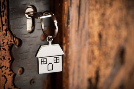 House shaped key chain on wooden door