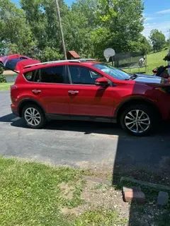 A red car is parked on the side of the road.