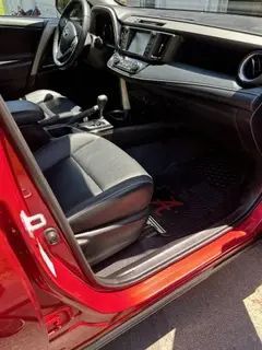 The inside of a red car with the door open.