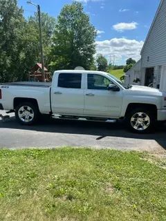 A white truck is parked in front of a house.