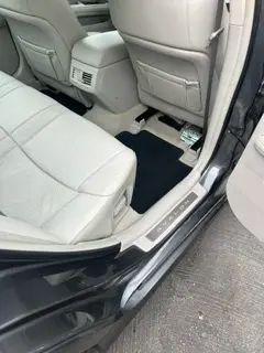 The back seat of a car with the door open.