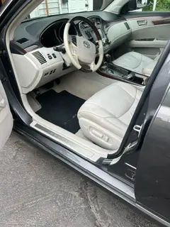 The interior of a car with the door open and the steering wheel visible.