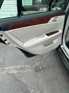 A car with the door open is parked in a parking lot.