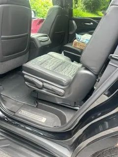 The back seat of a black suv with the door open.