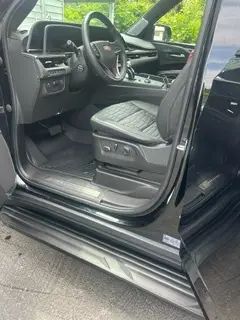 The inside of a black car with the door open.