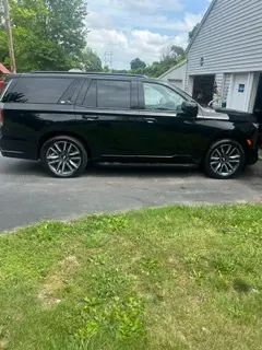 A black suv is parked in front of a garage.