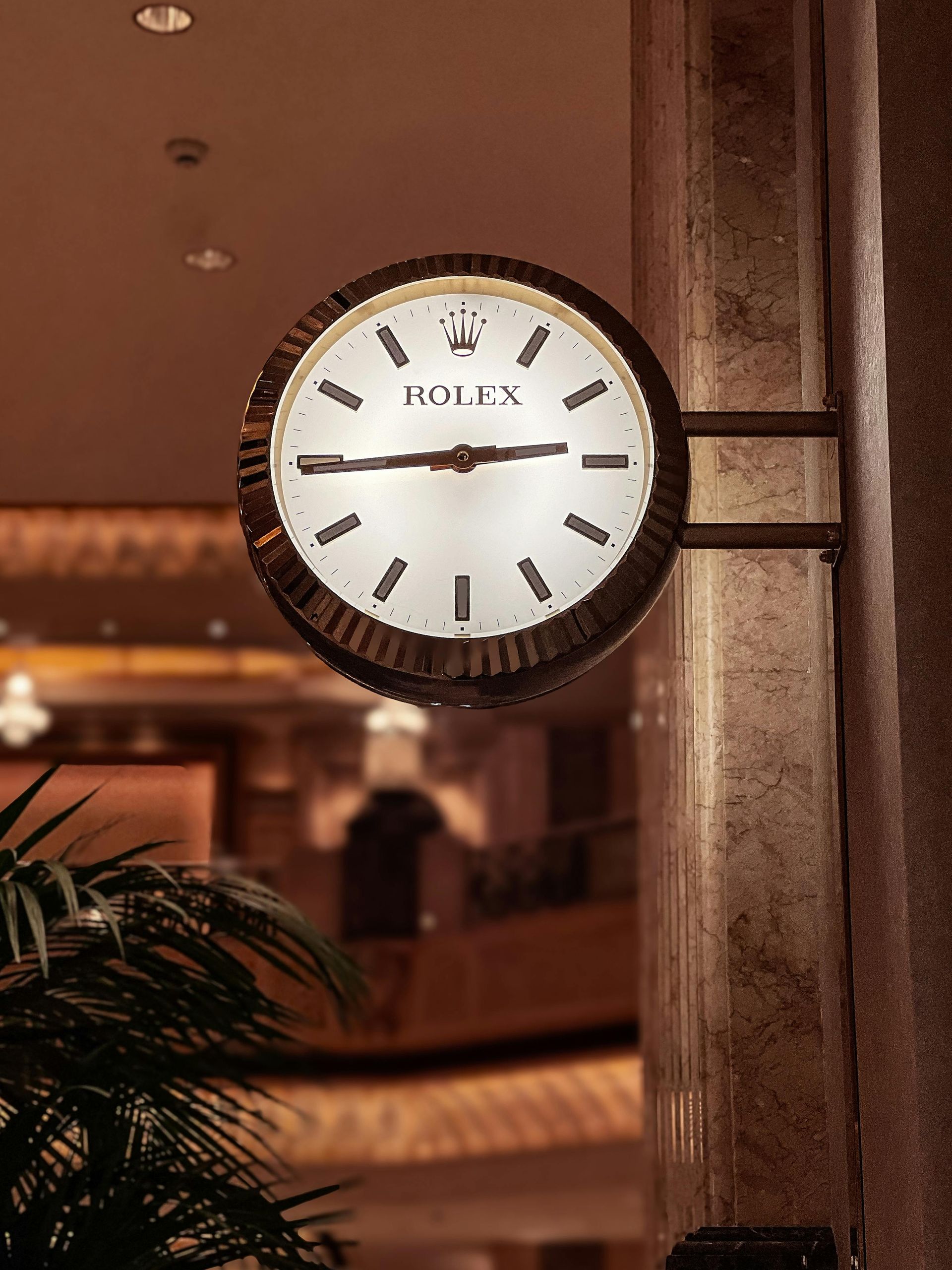 Rolex clock mounted on a column, inside a building.
