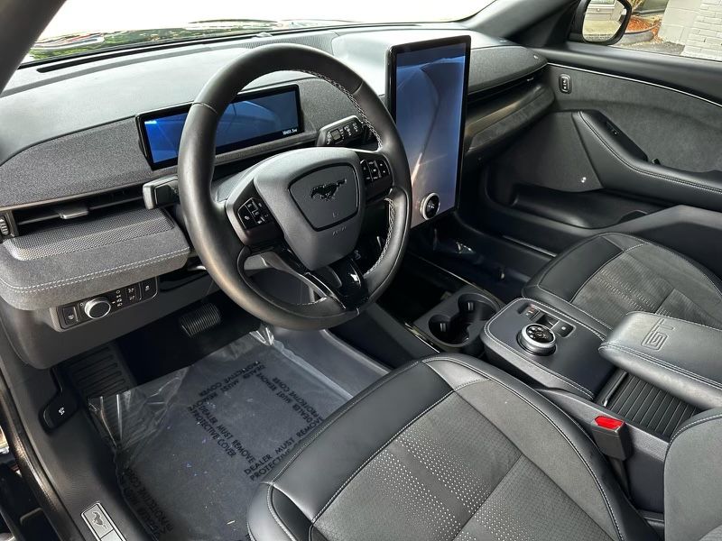 The interior of a ford mustang mach e with a tablet on the dashboard.