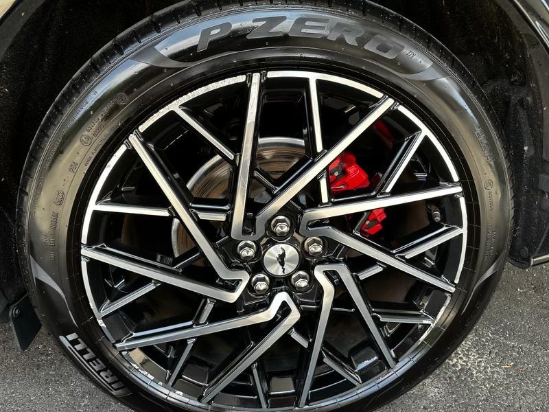 A close up of a car wheel with a pzero tire on it