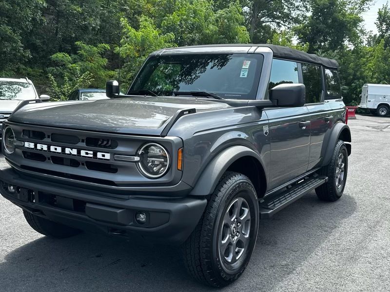 A gray ford bronco is parked in a parking lot.