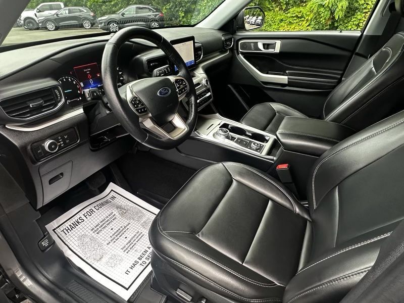 The interior of a ford explorer with a steering wheel and seats.