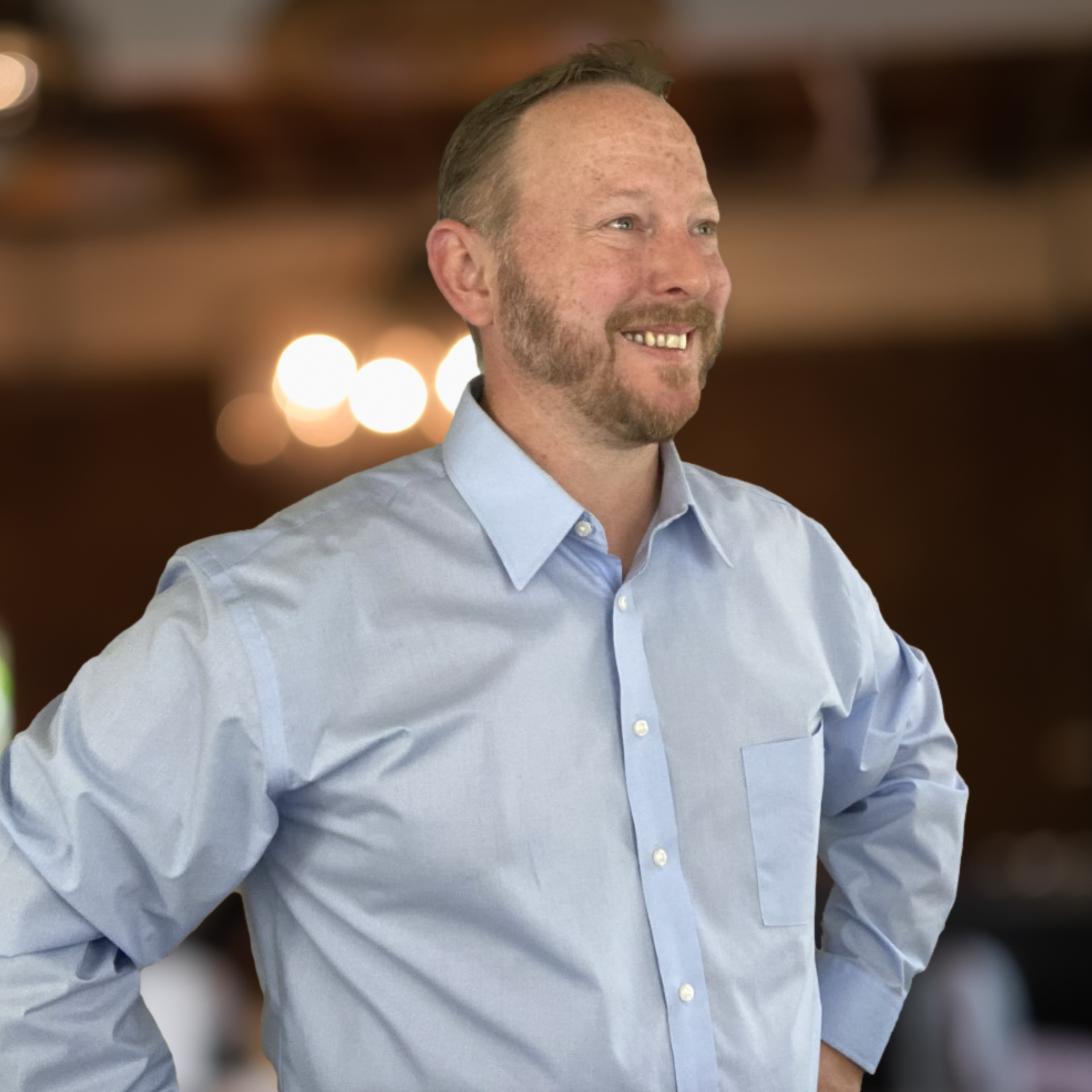A man with a beard is wearing a light blue shirt