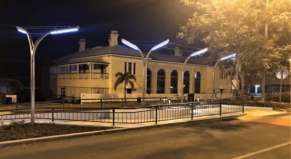 A Large Building With A Lot Of Windows Is Lit Up At Night — Integrabuild in Bowen, QLD