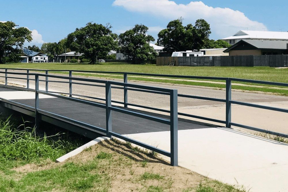 A Bridge Over A River With A Fence Around It — Integrabuild in Bowen, QLD