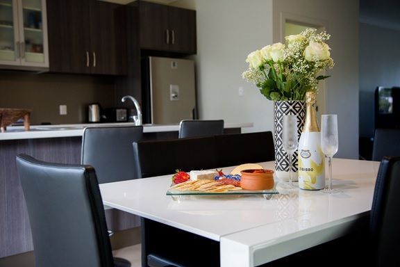 A dining room table with a vase of flowers on it — Integrabuild in Bowen, QLD