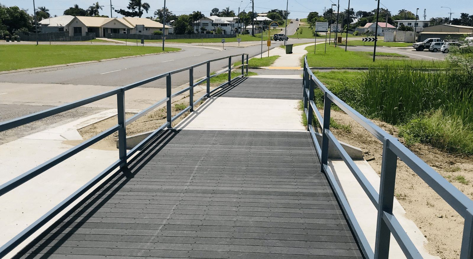 A wooden bridge with a metal railing going over a body of water — Integrabuild in Bowen, QLD