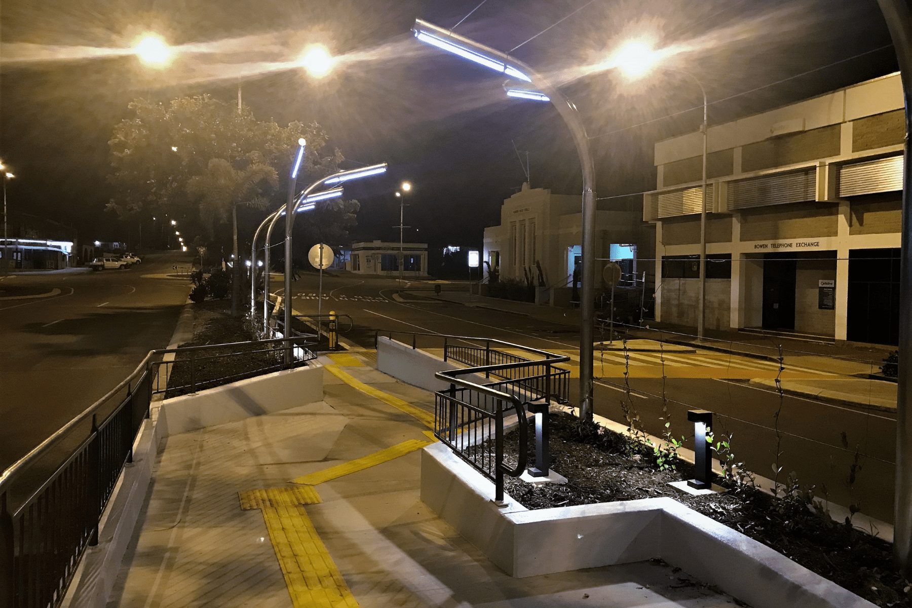 A row of street lights are lit up at night in front of a building — Integrabuild in Bowen, QLD