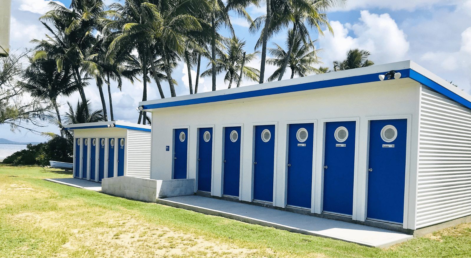 A row of blue and white buildings with palm trees in the background — Integrabuild in Bowen, QLD