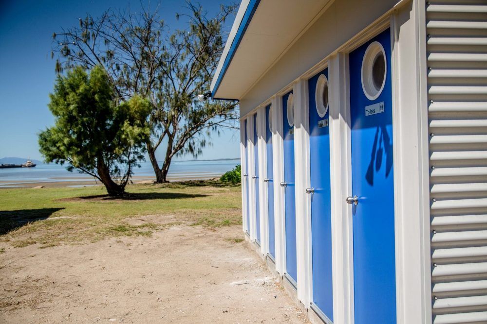 A row of blue and white changing rooms on a beach — Integrabuild in Bowen, QLD