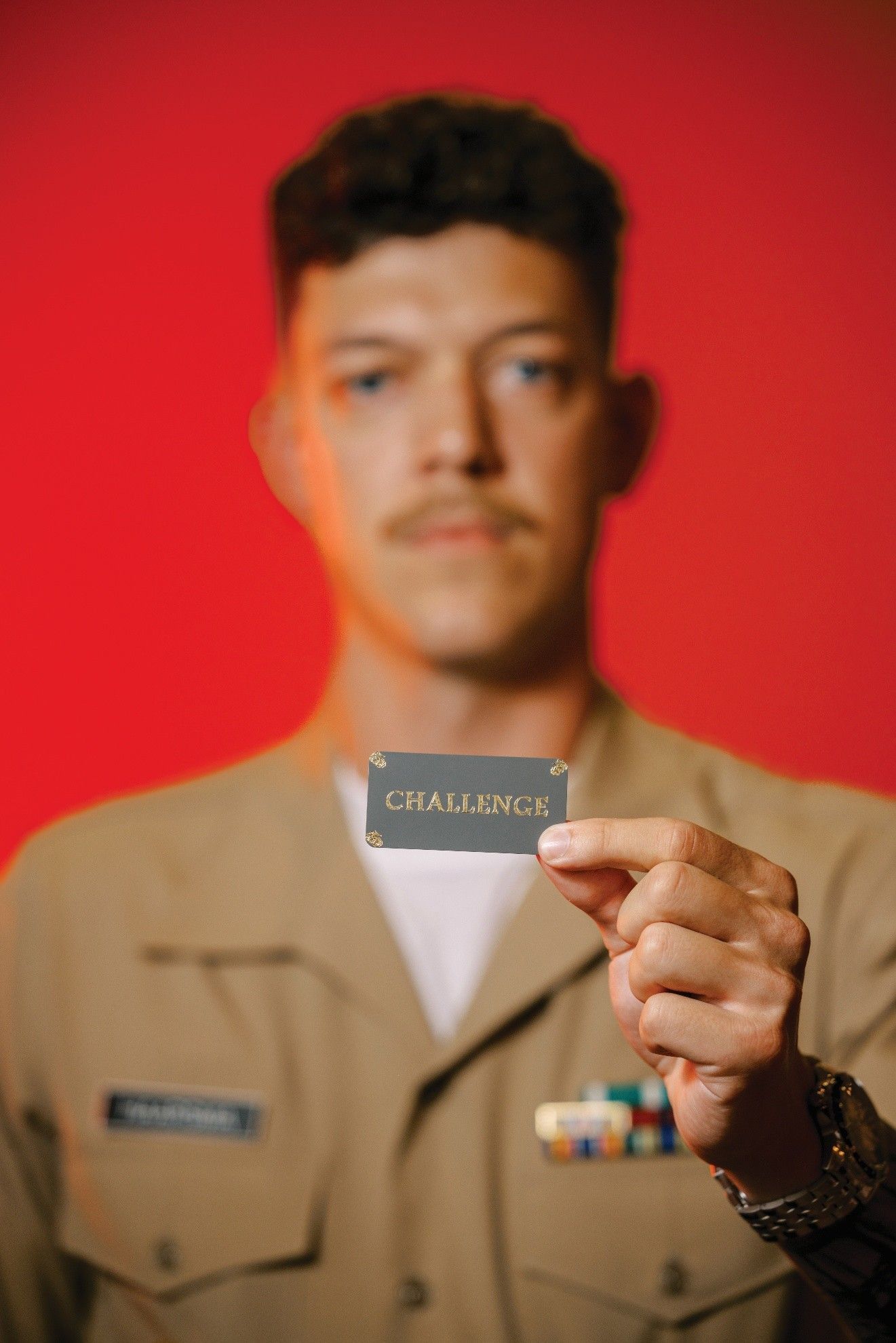 Man in uniform holding a name tag that reads 