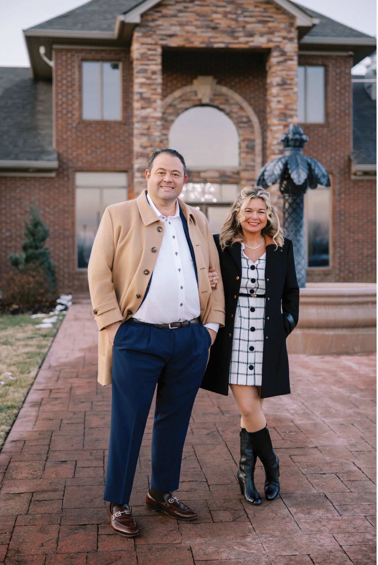 Santa Claus decorating a Christmas tree with red and gold ornaments in a well-lit living room.