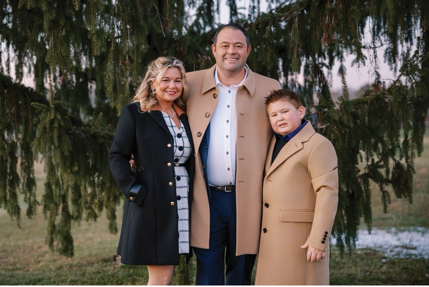 Santa Claus sits in a chair with a woman beside him, in a room decorated for Christmas.