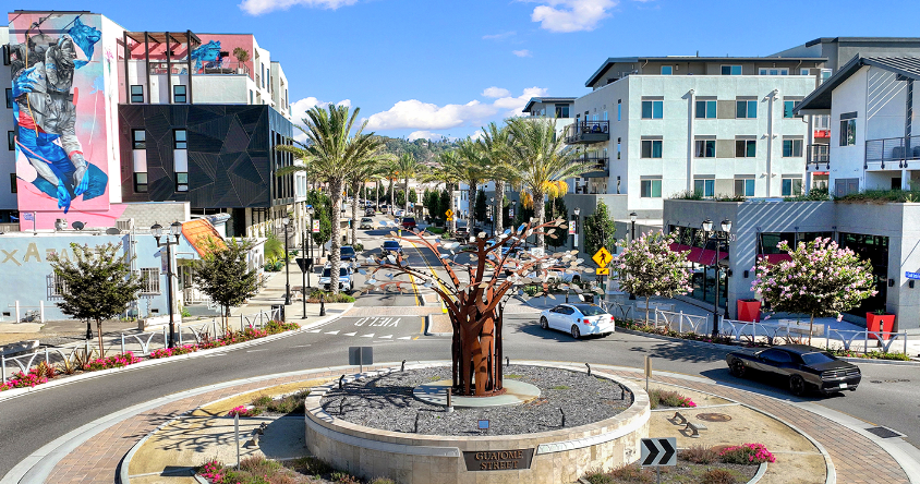 A car is driving through a roundabout in a city.