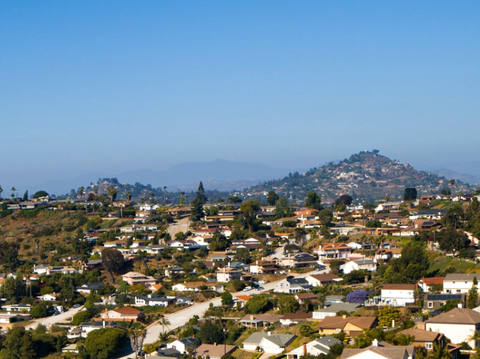 An aerial view of a residential area with a mountain in the background