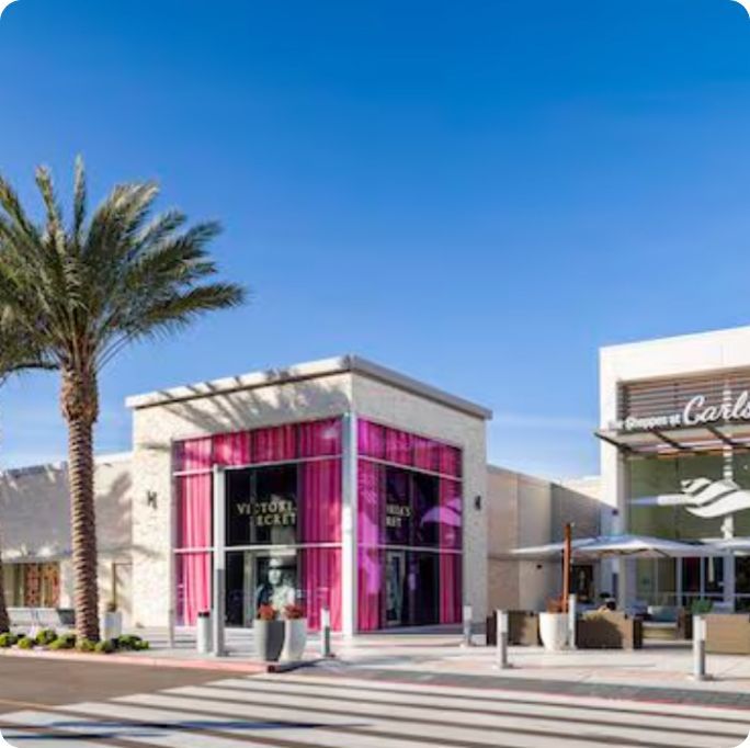 A building with pink curtains and a palm tree in front of it.