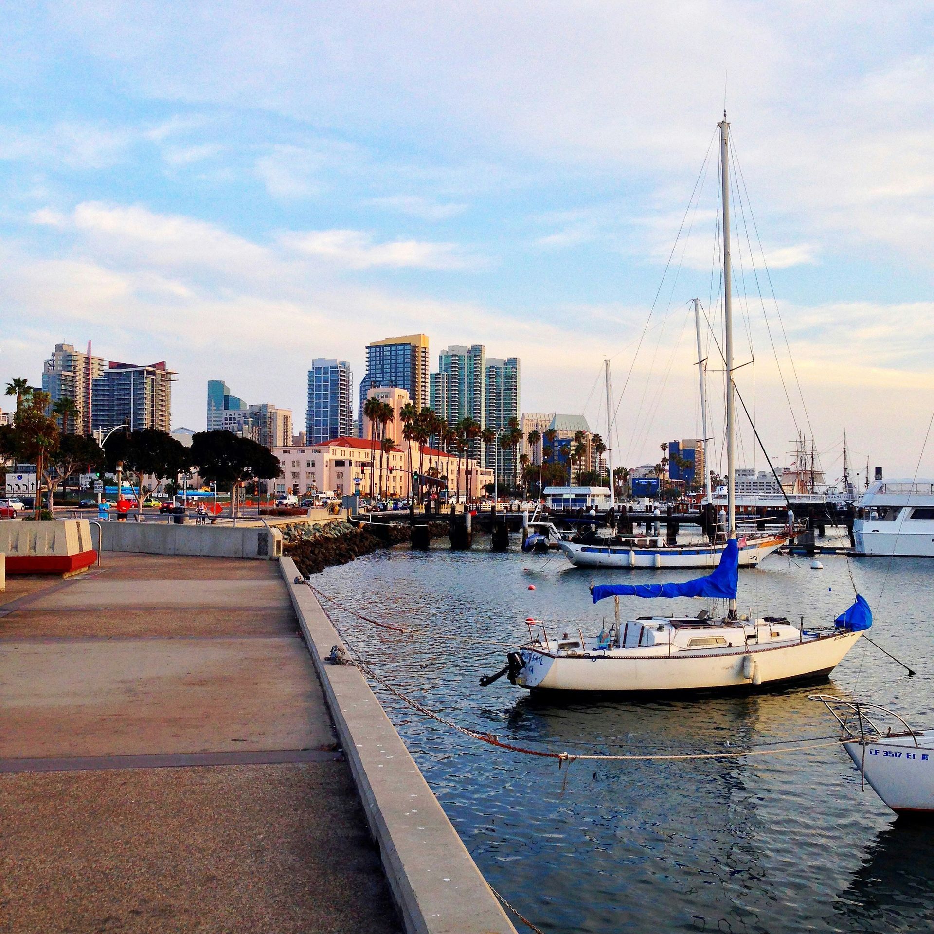 Boats are docked in a harbor with a city in the background