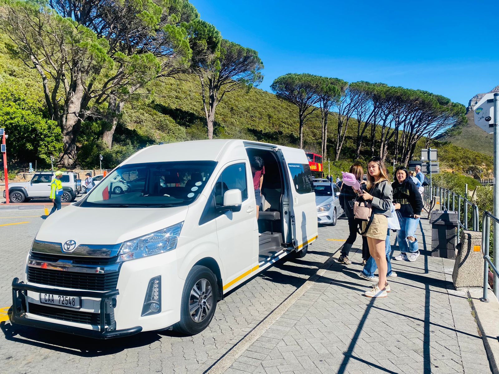 A group of people are standing next to a white van.