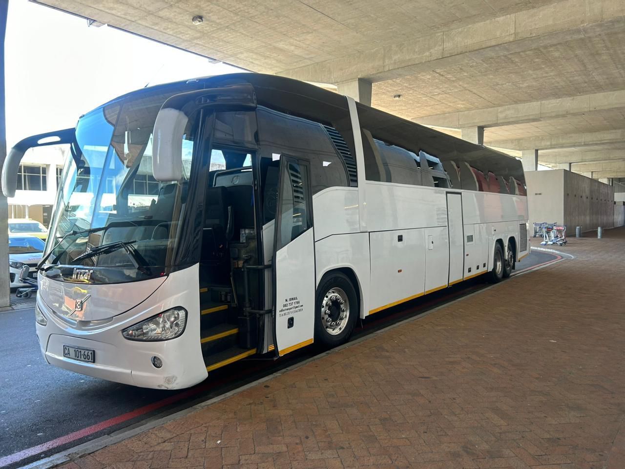 A large white bus is parked on the side of the road.