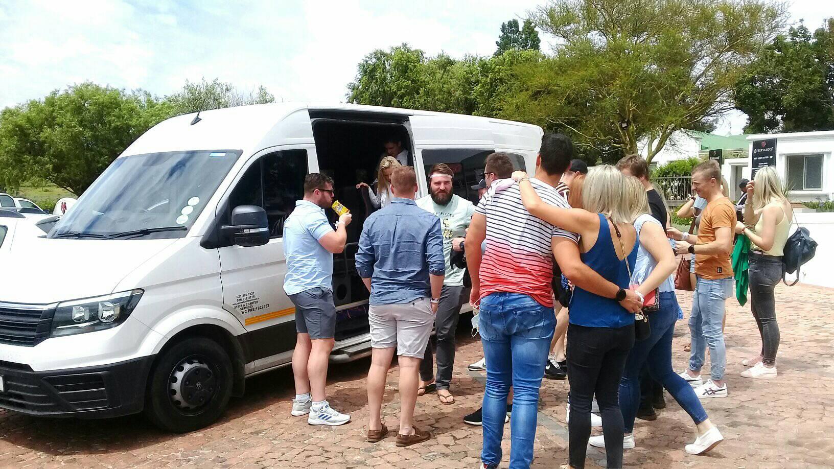 A group of people are standing around a white van.