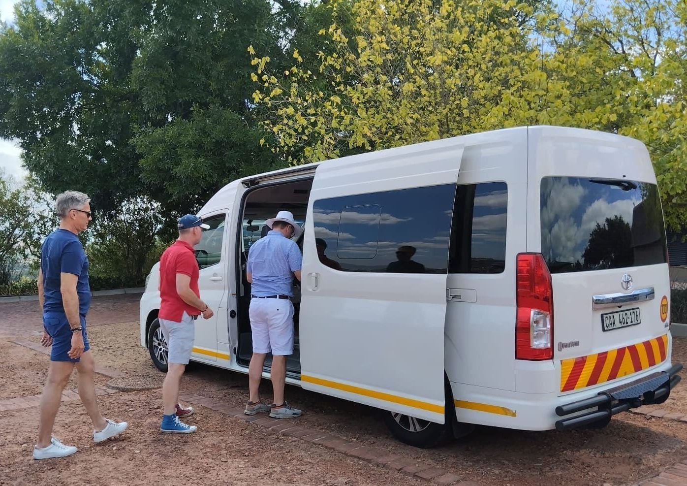 A group of men are standing next to a white van.