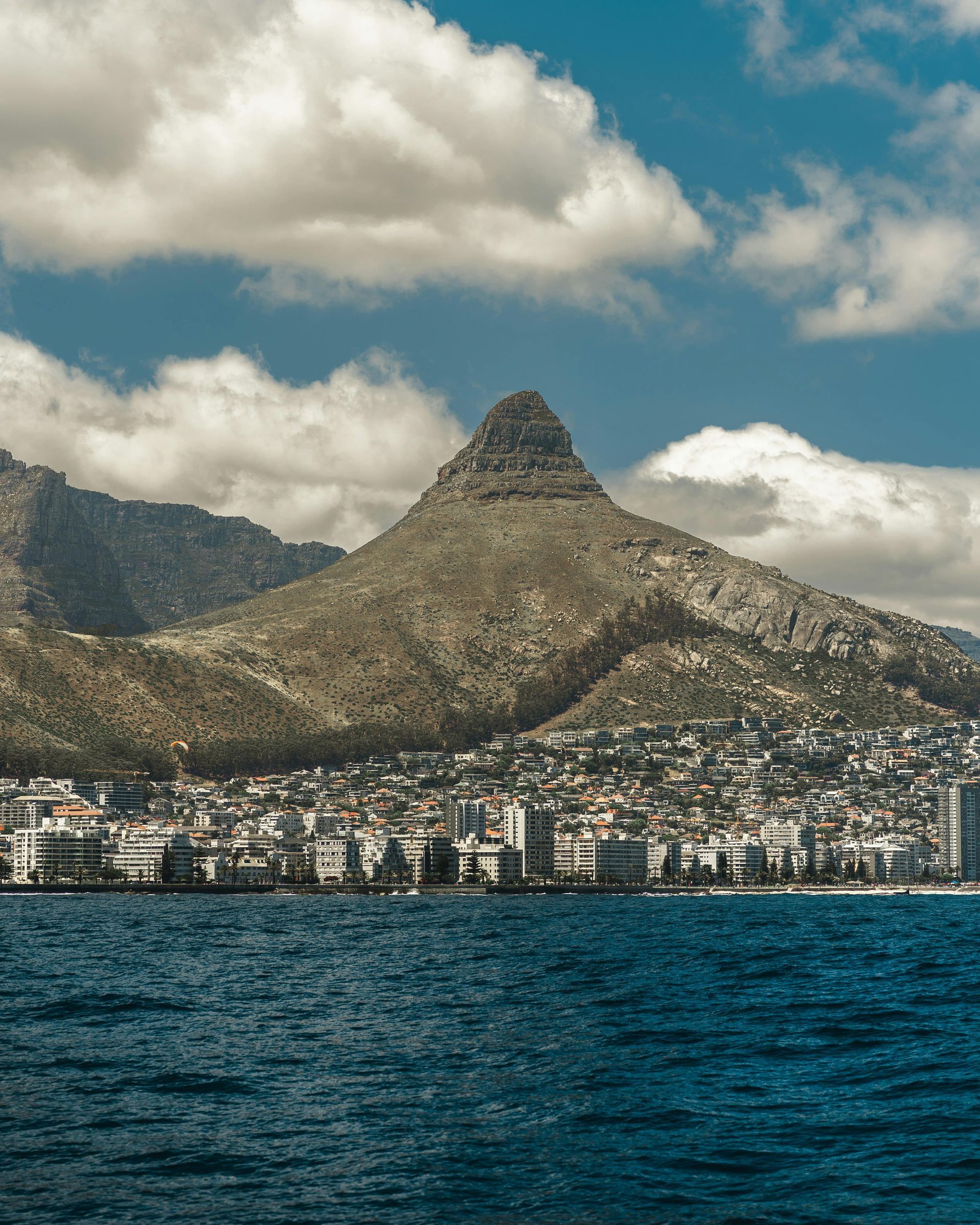 A city with a mountain in the background and a body of water in the foreground.