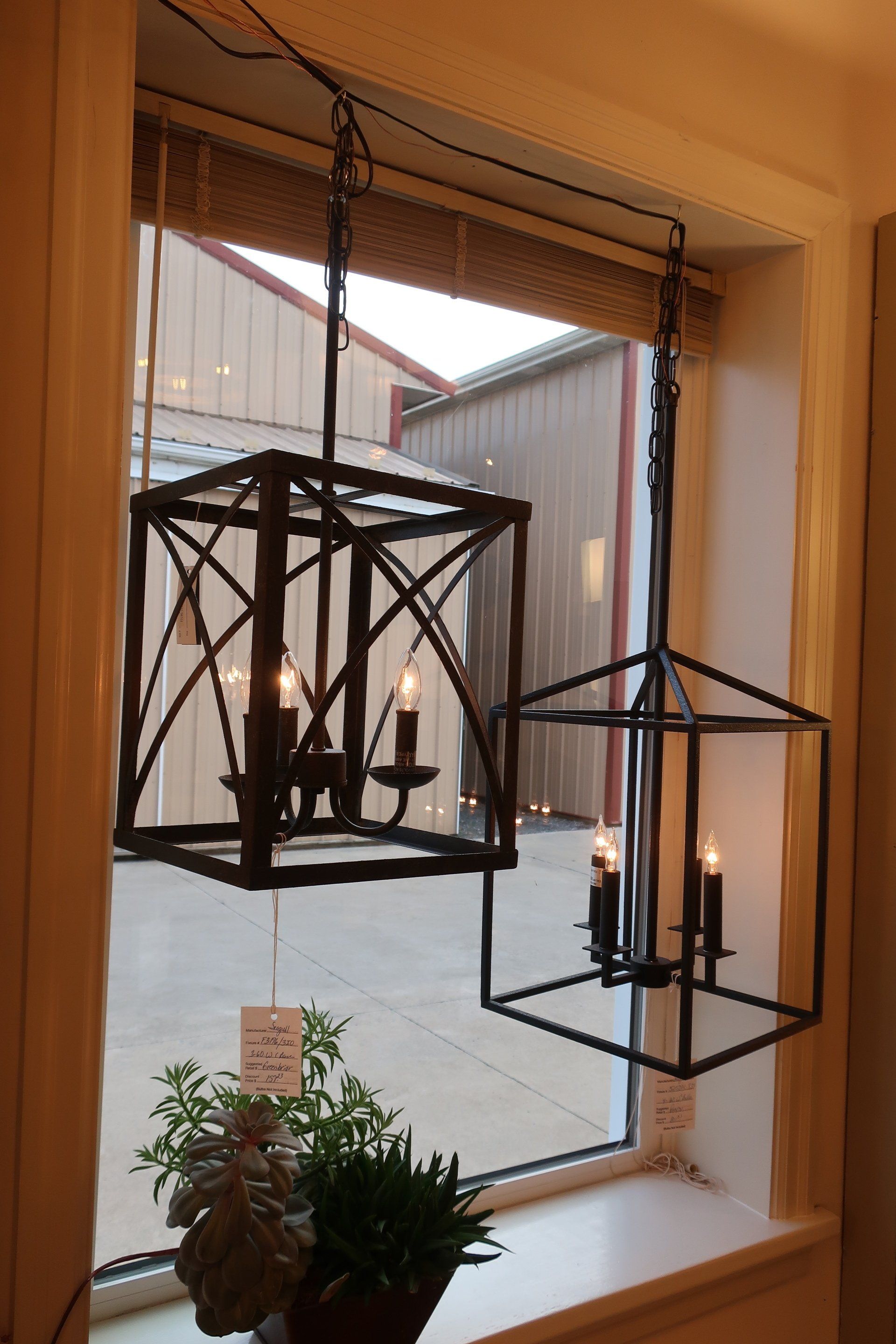 Two lanterns are hanging from the ceiling in front of a window.