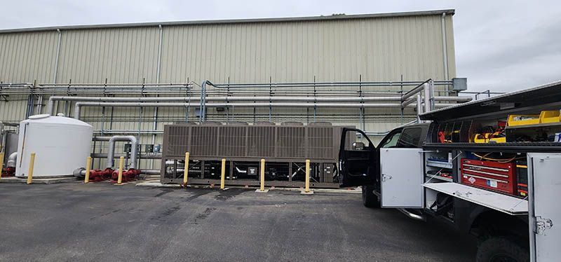 A truck is parked in a parking lot in front of a building.