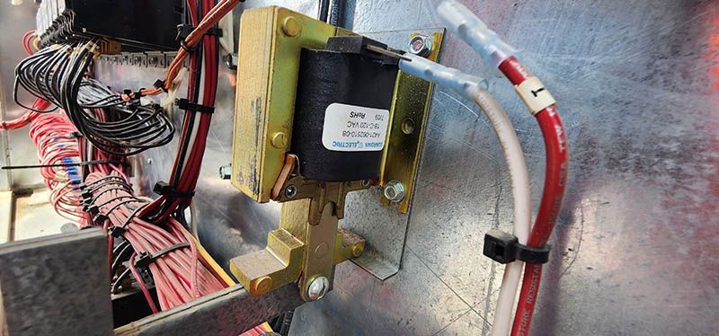 A close up of a transformer and wires on a wall.