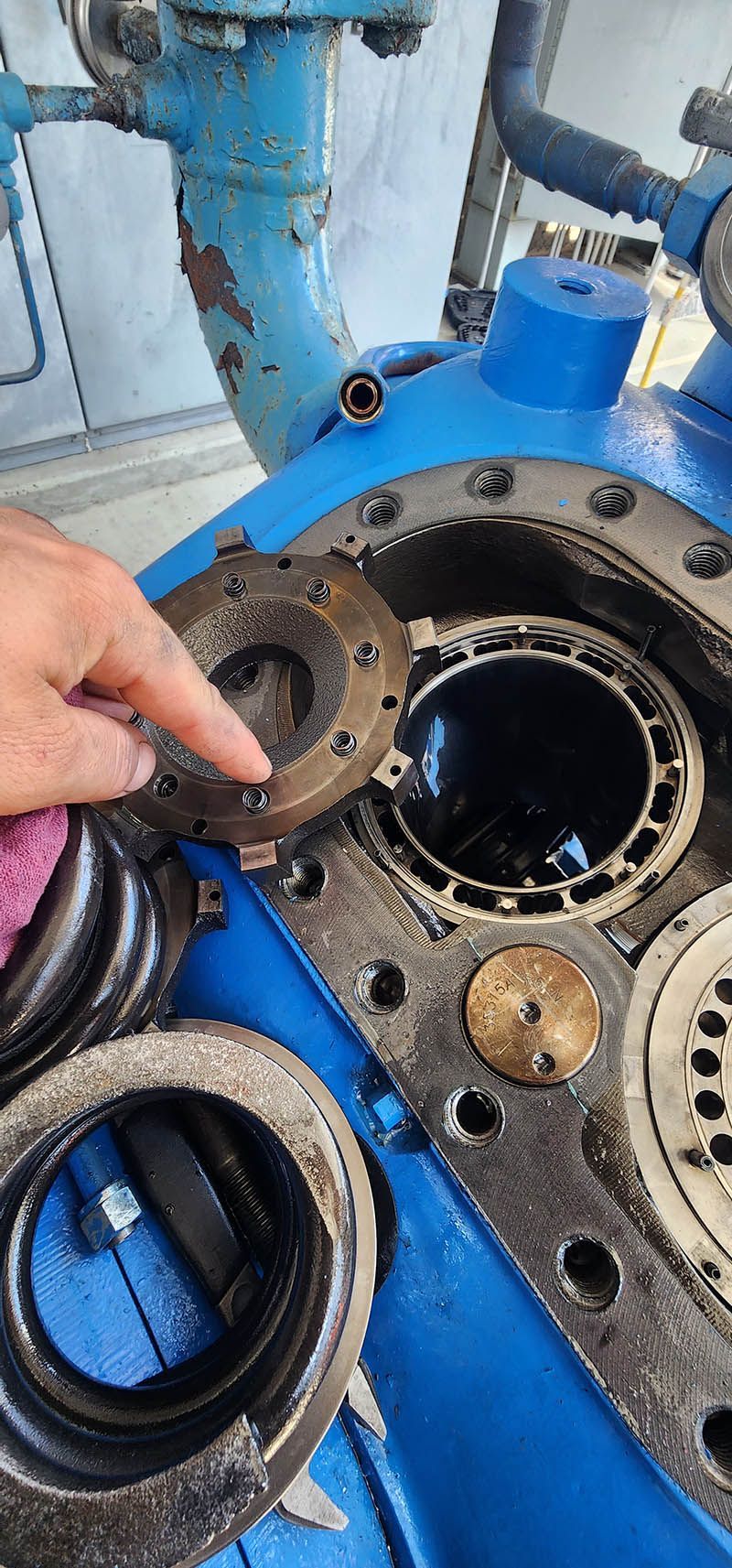 A person is cleaning a machine with a sponge.
