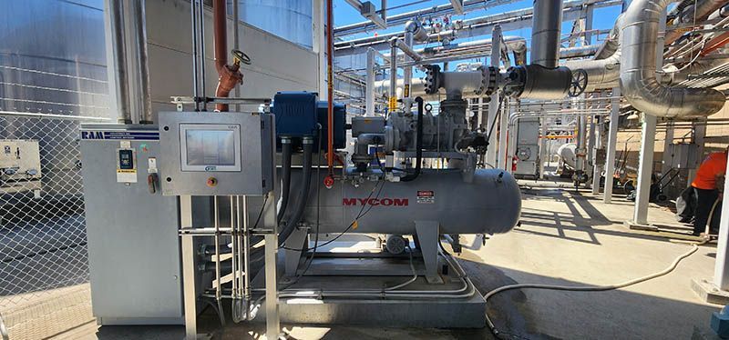 A large compressor is sitting in the middle of a factory.