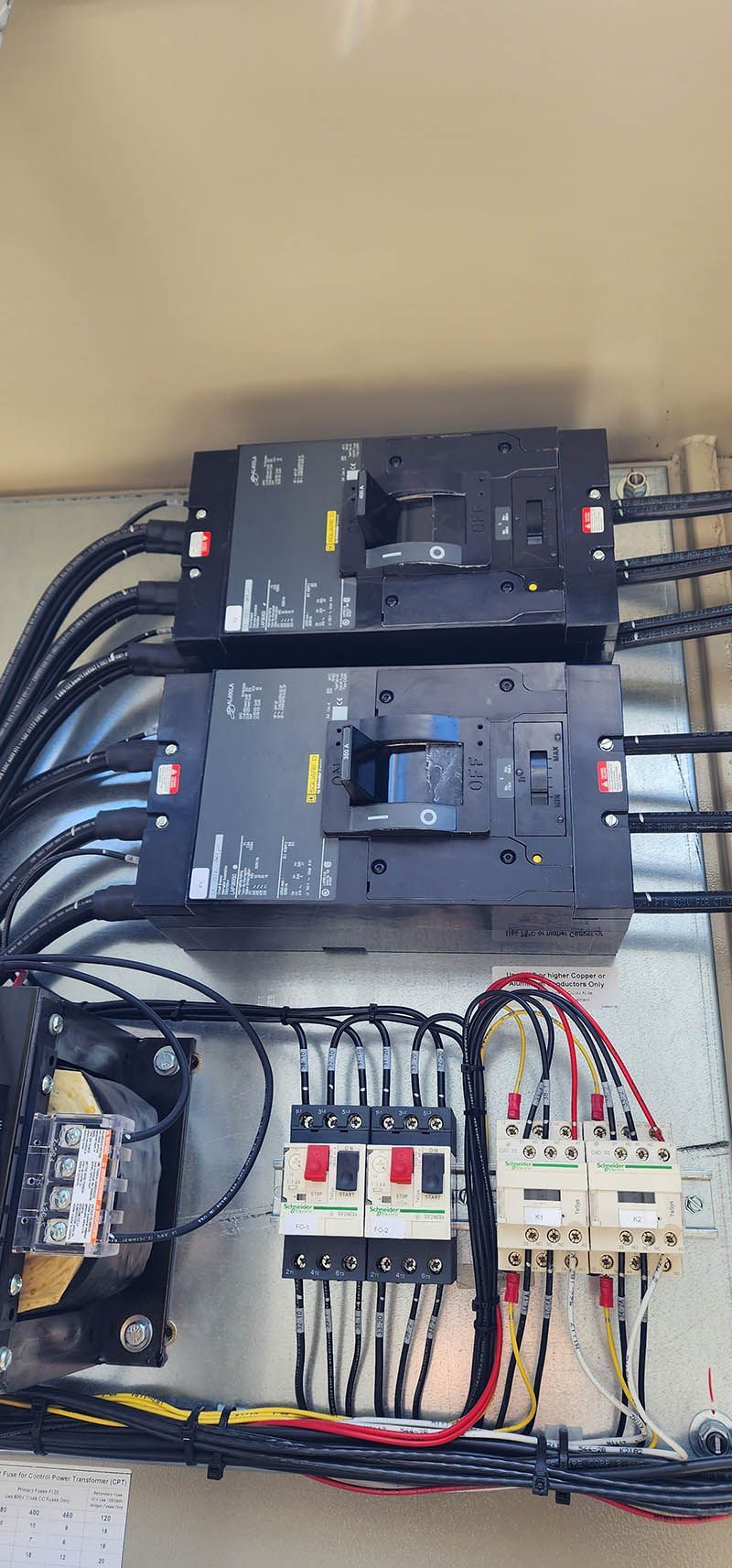 A close up of a electrical panel with a lot of wires coming out of it.