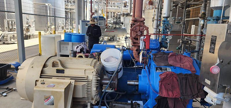 A man is working on a large machine in a factory.