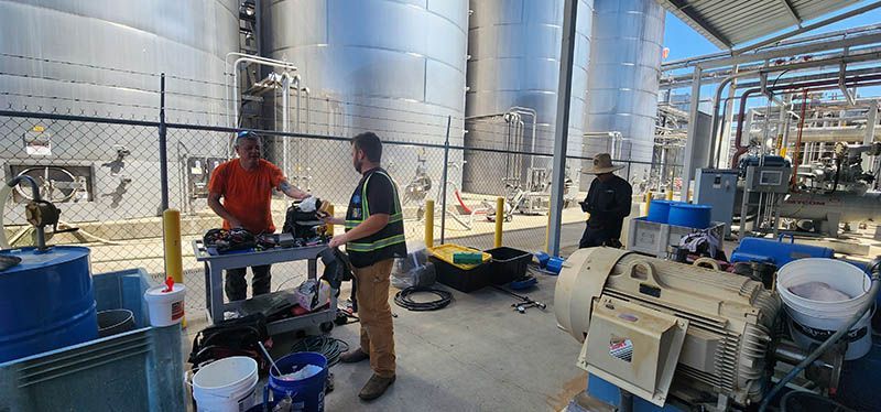 A group of men are working on a machine in a factory.