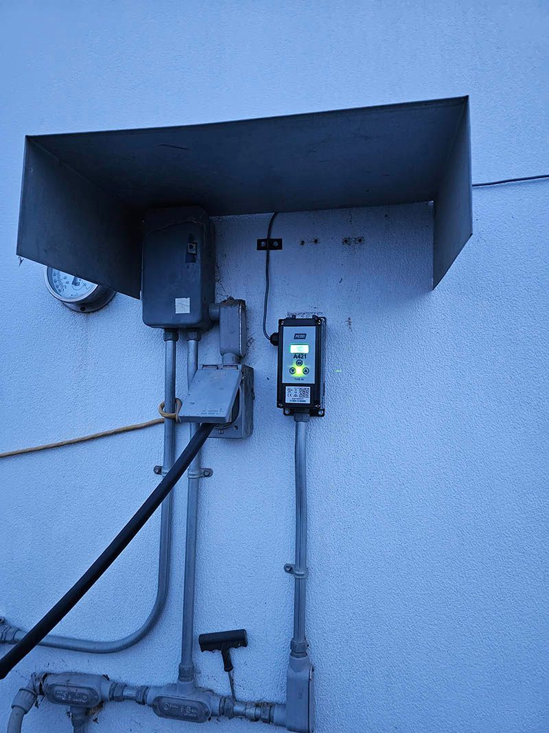 A white wall with a lot of wires hanging from it