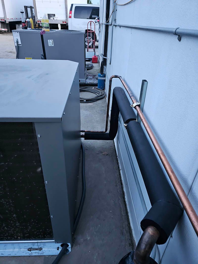 A copper pipe is attached to the side of a building