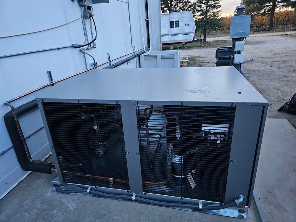 A large air conditioner is sitting on the side of a building.